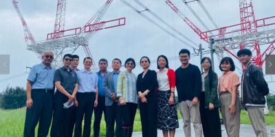 Undated souvenir photo (Radio Taiwan International): RTI hosts visiting Fu Hsing Radio staff at Tamsui transmitters' site, with thirteen people in front of two antenna carriers